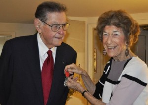Carol Diamond, Ted Diamond's wife of 69 years, pins "Legion of Honor Medal" to Ted's jacket.